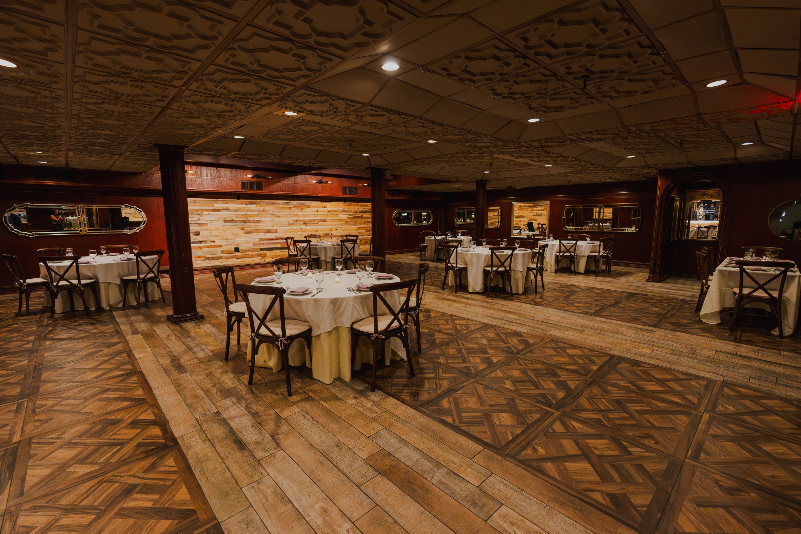 The Tosca Room set with round tables, columns and a parquet floor